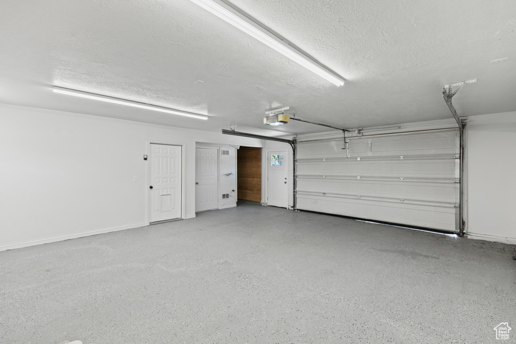 Garage with a garage door opener and baseboards