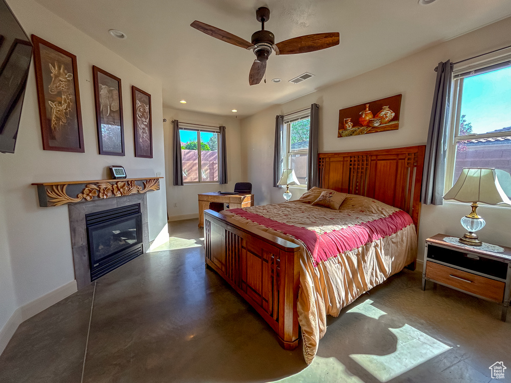 Bedroom featuring baseboards, a glass covered fireplace, visible vents, recessed lighting, and ceiling fan