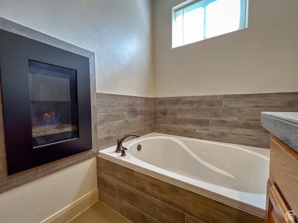 Full bathroom featuring a garden tub and vanity