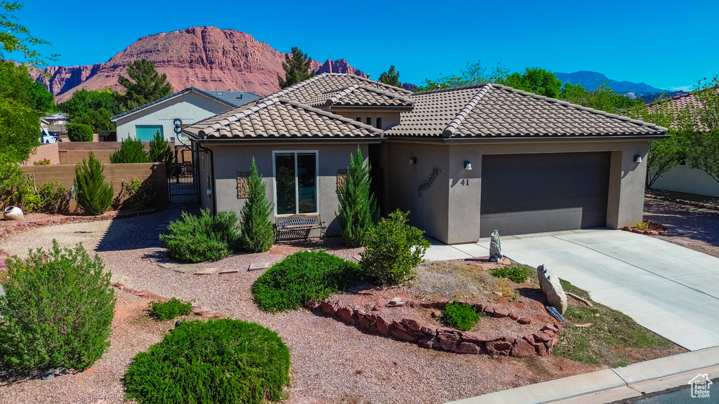 View of front of property featuring a garage, a mountain view, and stucco siding