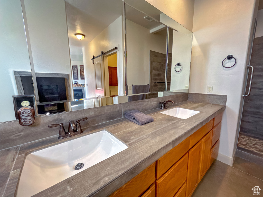 Full bathroom with double vanity, visible vents, tile patterned floors, and a sink