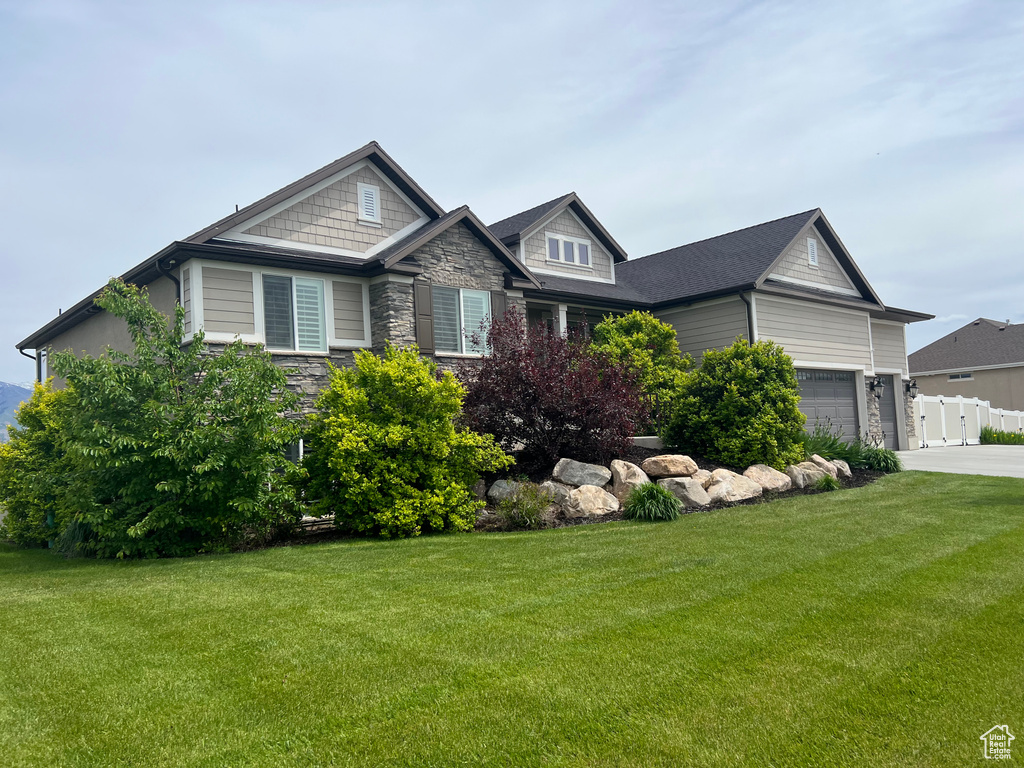 Craftsman house featuring stone siding, concrete driveway, and an attached garage