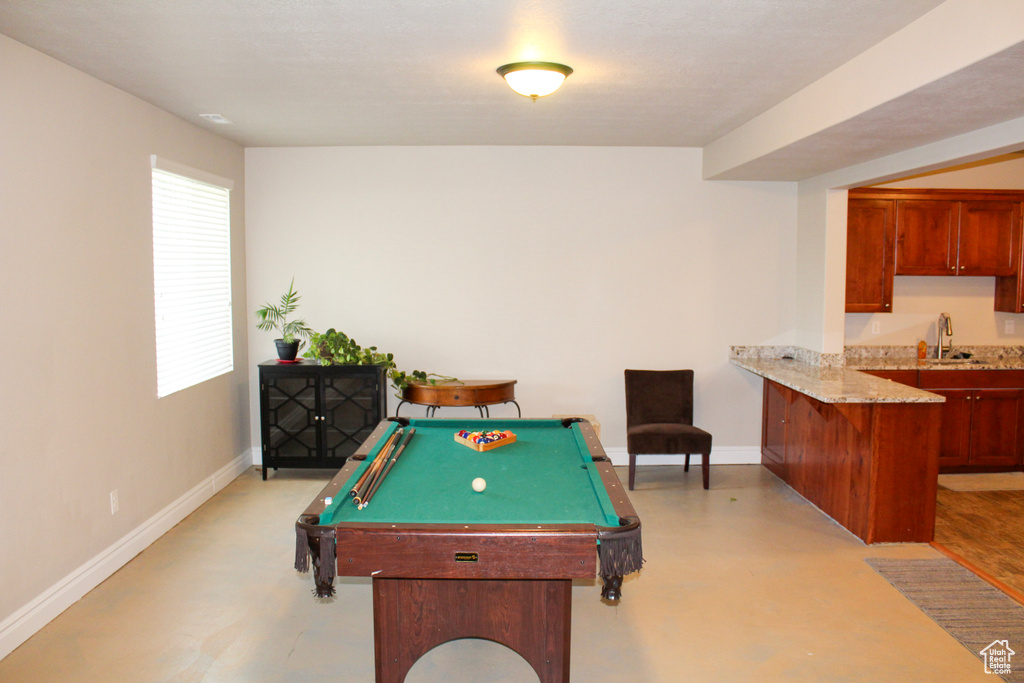 Playroom with finished concrete flooring, billiards, baseboards, and bar area