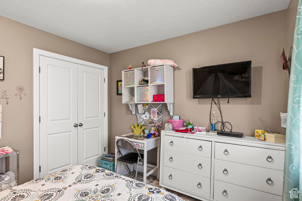 Bedroom featuring a textured ceiling and a closet