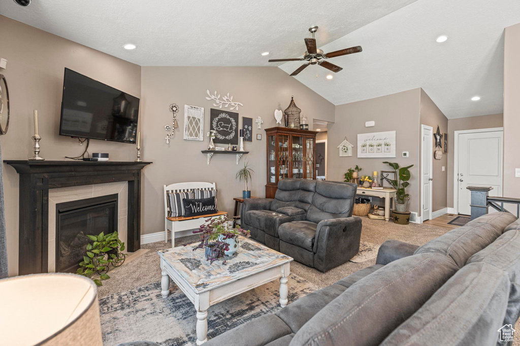 Living area featuring carpet flooring, vaulted ceiling, a glass covered fireplace, recessed lighting, and ceiling fan