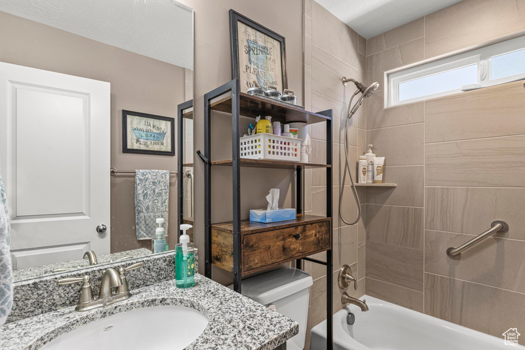 Bathroom featuring shower / bathtub combination, vanity, and toilet