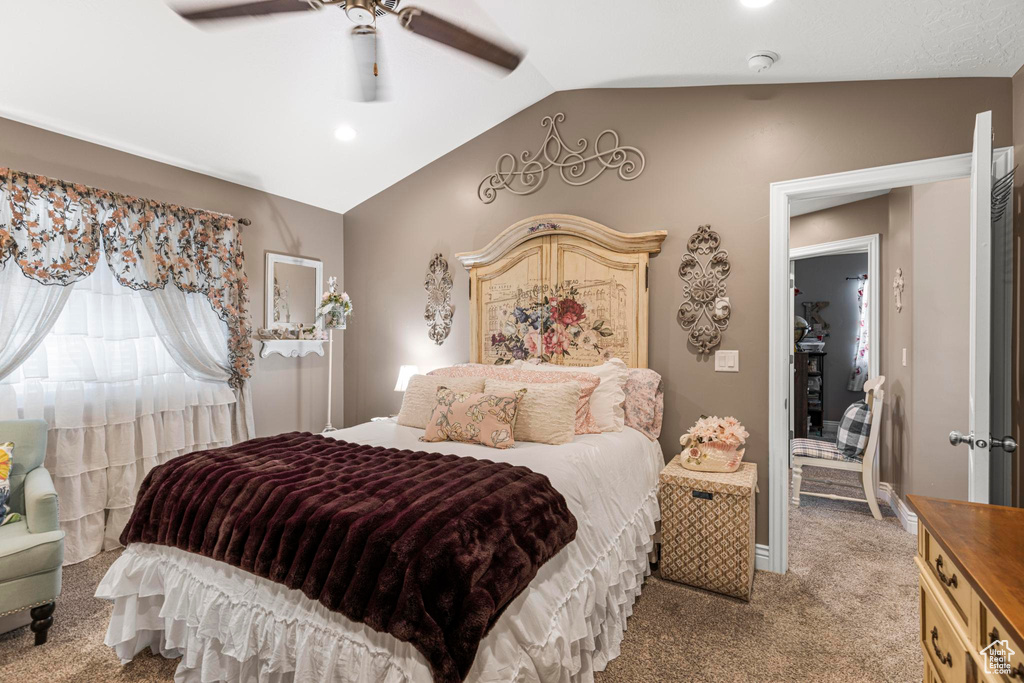 Carpeted bedroom featuring vaulted ceiling, baseboards, and a ceiling fan
