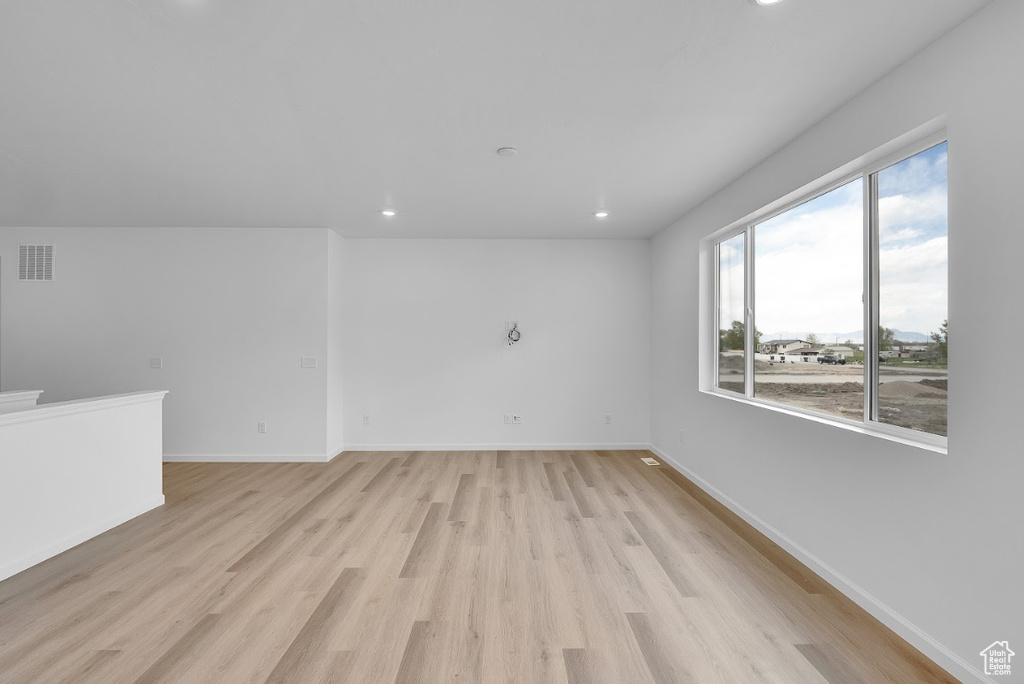 Unfurnished room featuring light wood-style floors, recessed lighting, and baseboards
