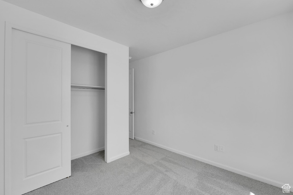 Unfurnished bedroom featuring carpet flooring, a closet, and baseboards