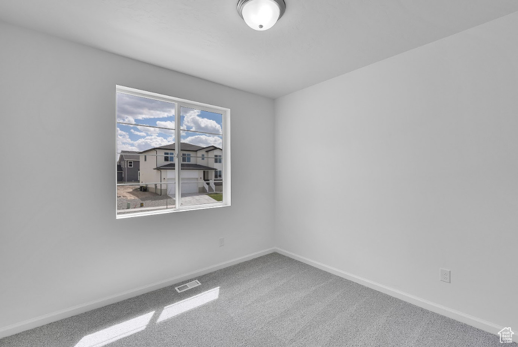 Carpeted empty room featuring baseboards