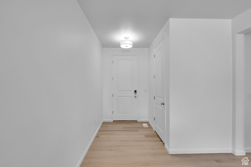 Hall with light wood finished floors and baseboards