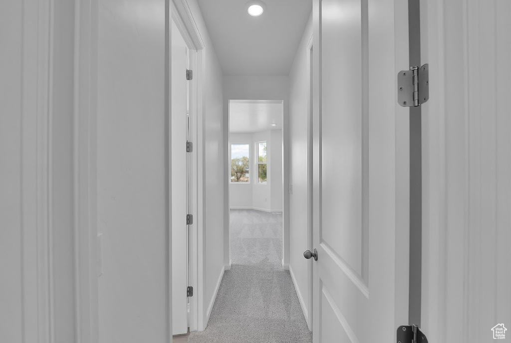 Hall with baseboards, light colored carpet, and recessed lighting