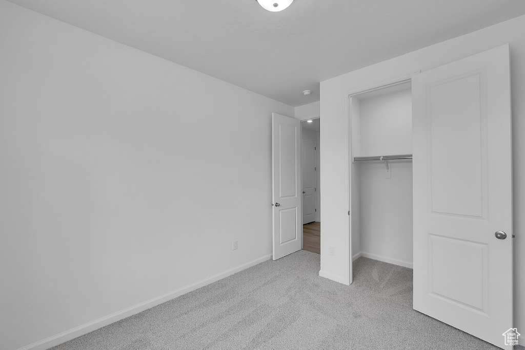 Unfurnished bedroom with carpet, baseboards, and a closet