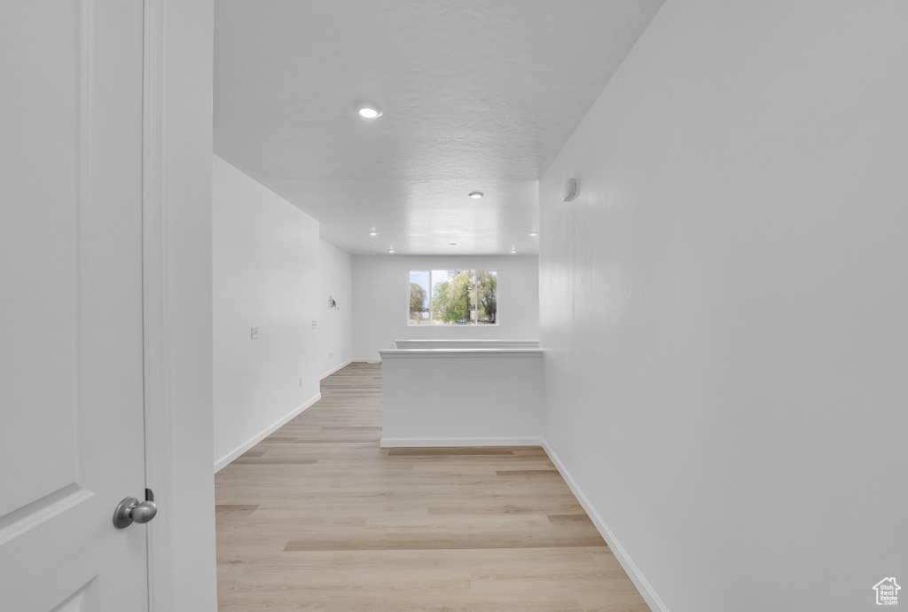 Spare room with baseboards, light wood-style floors, and recessed lighting