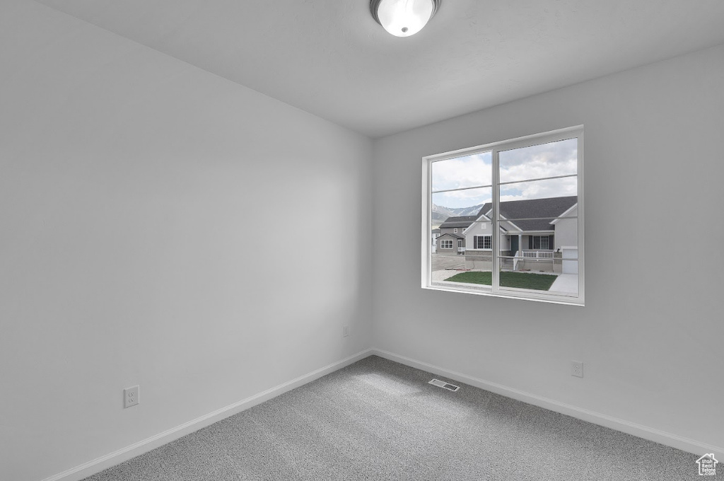 Spare room with baseboards and carpet floors