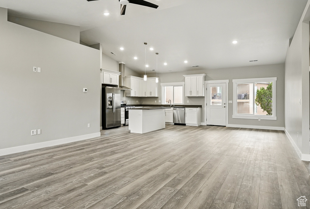 Unfurnished living room with ceiling fan, plenty of natural light, light wood-style floors, recessed lighting, and high vaulted ceiling