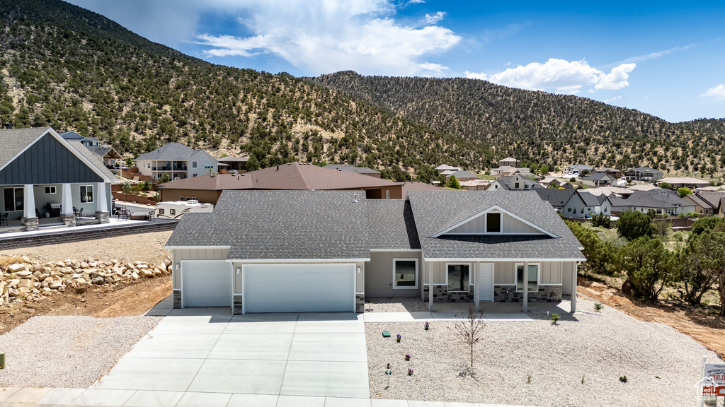 View of front of property featuring a porch, roof with shingles, a residential view, and concrete driveway