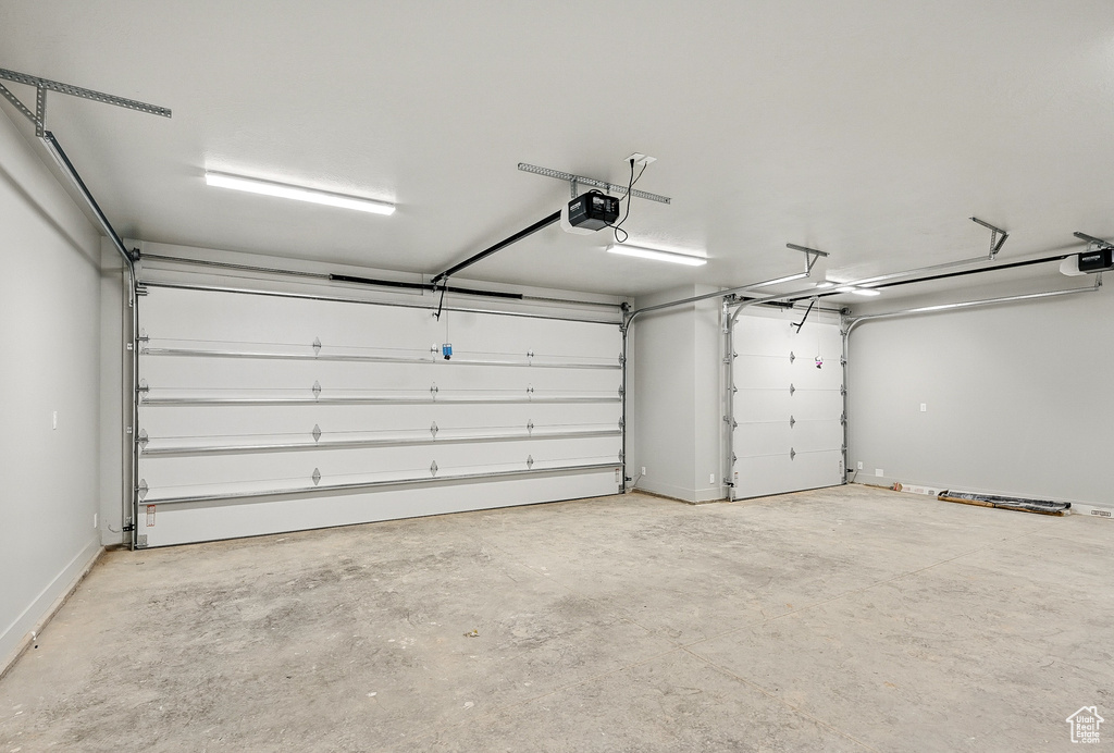 Garage with a garage door opener and baseboards