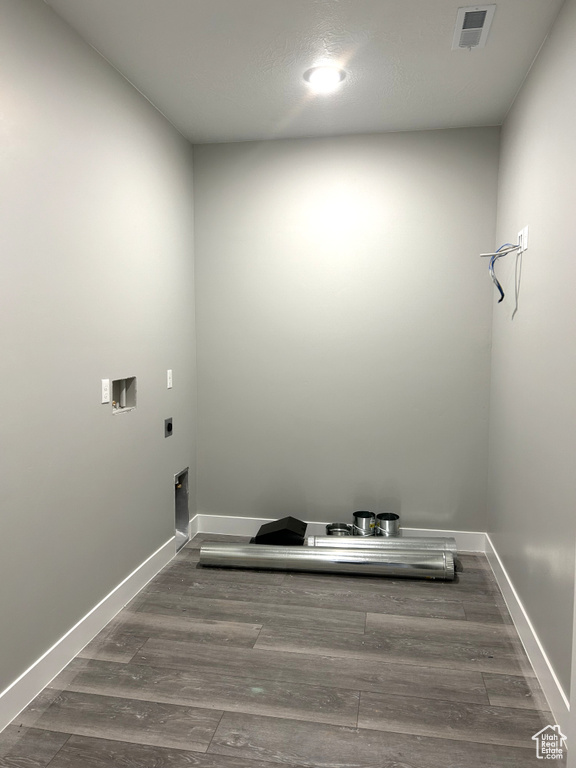 Laundry room with electric dryer hookup, visible vents, wood finished floors, and laundry area
