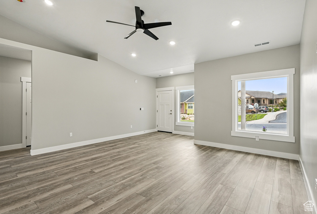 Unfurnished living room featuring wood finished floors, a ceiling fan, baseboards, and recessed lighting