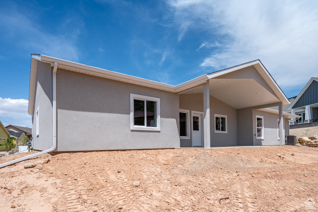 Back of property featuring stucco siding and central air condition unit