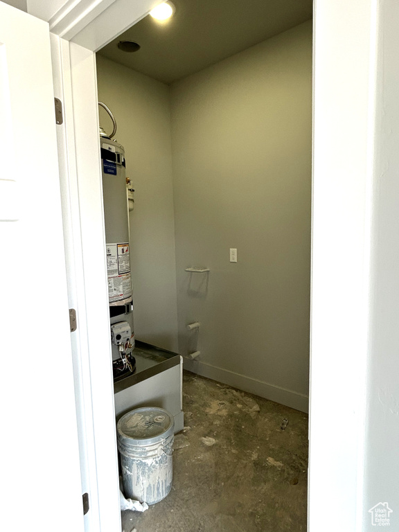 Bathroom with water heater and unfinished concrete floors