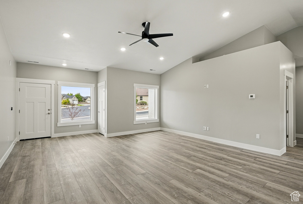 Unfurnished living room with a ceiling fan, wood finished floors, recessed lighting, baseboards, and vaulted ceiling