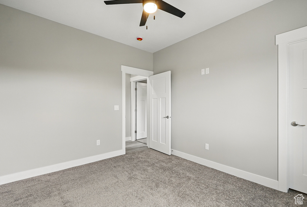 Unfurnished room with carpet flooring, ceiling fan, and baseboards