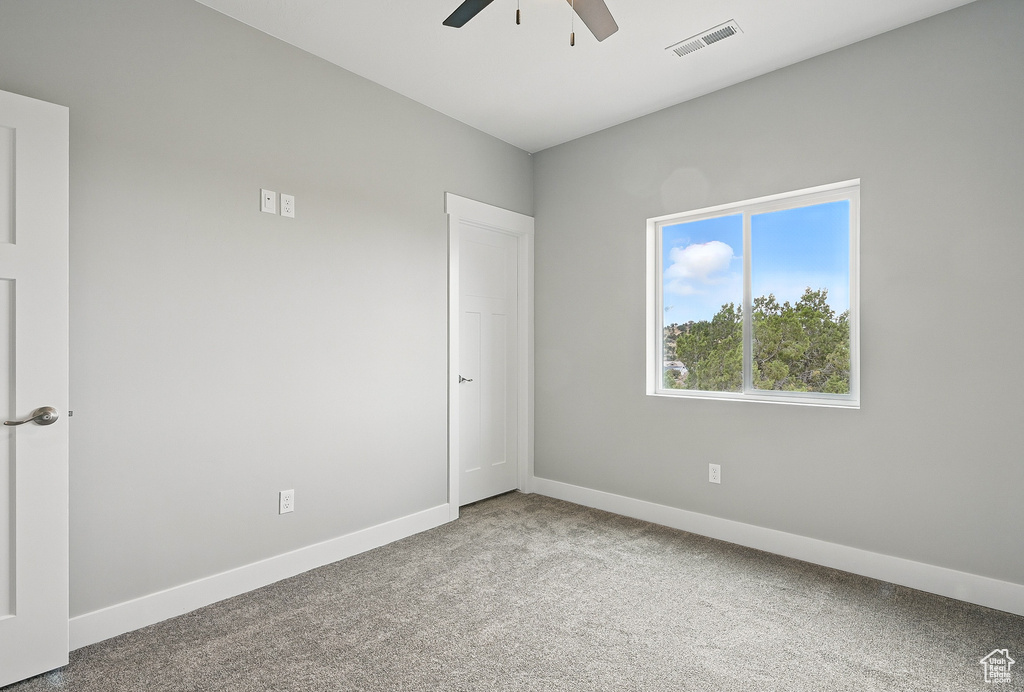 Empty room with ceiling fan, carpet, and baseboards