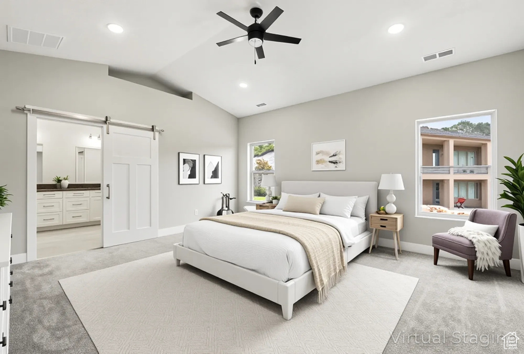 Bedroom featuring a barn door, light colored carpet, vaulted ceiling, baseboards, and connected bathroom