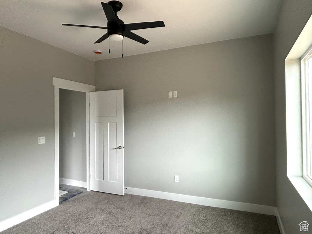 Spare room featuring ceiling fan, baseboards, and carpet flooring