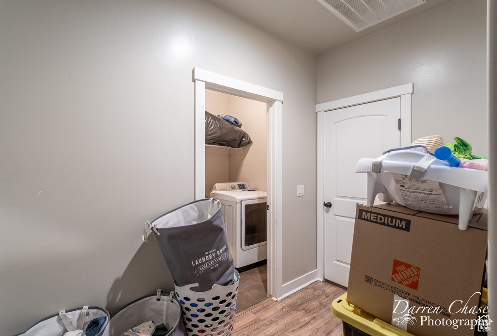 Laundry area featuring washer / dryer, visible vents, light wood-style floors, and laundry area
