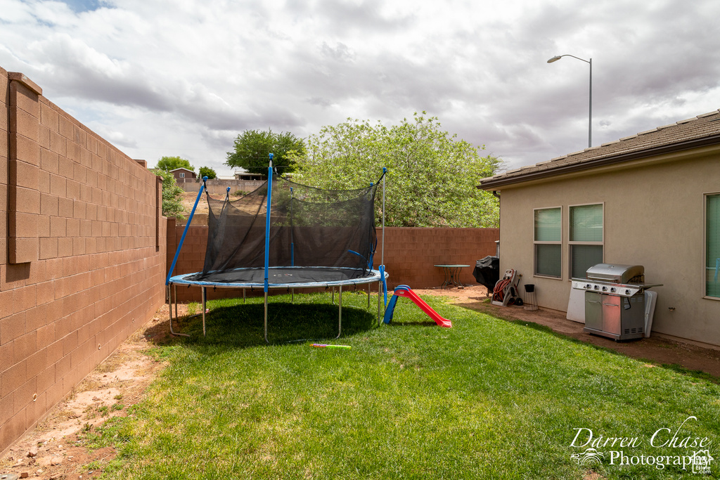 View of yard featuring a fenced backyard and a trampoline