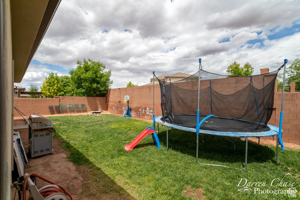 View of yard featuring a fenced backyard and a trampoline