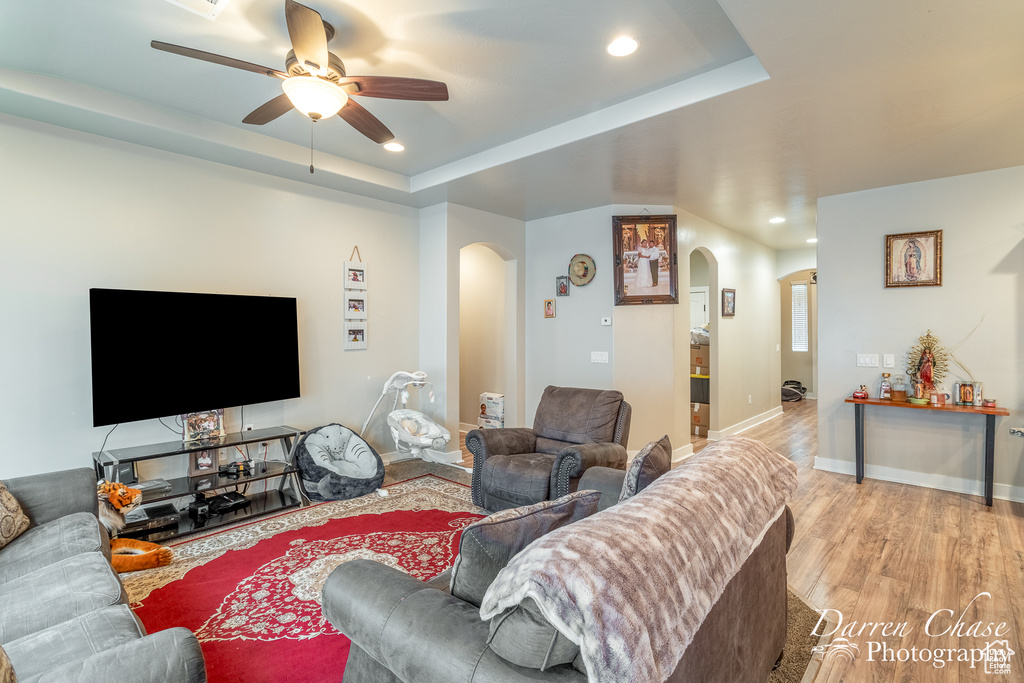 Living area with ceiling fan, arched walkways, wood finished floors, and recessed lighting