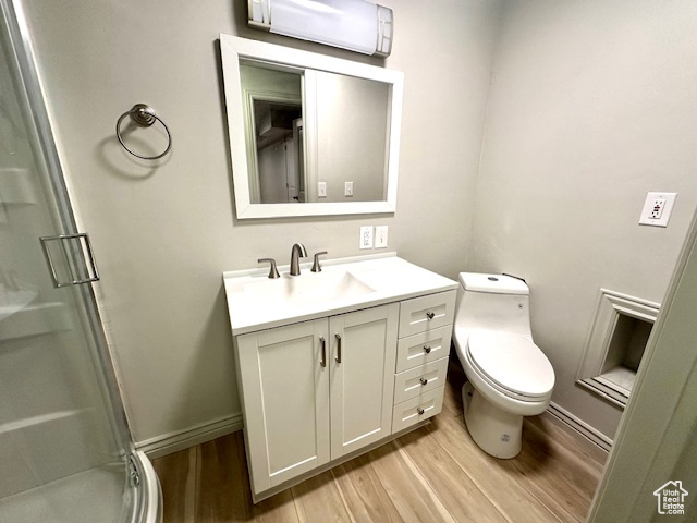 Bathroom featuring wood finished floors, vanity, and a stall shower