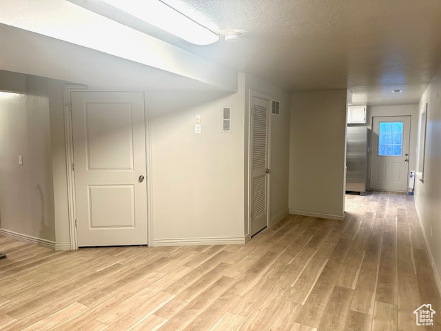 Unfurnished room with light wood-style flooring, visible vents, and baseboards