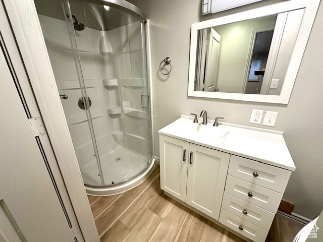 Full bath with a shower stall, wood finished floors, and vanity