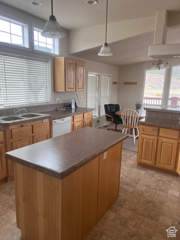 Kitchen with dark countertops, white dishwasher, plenty of natural light, a sink, and recessed lighting