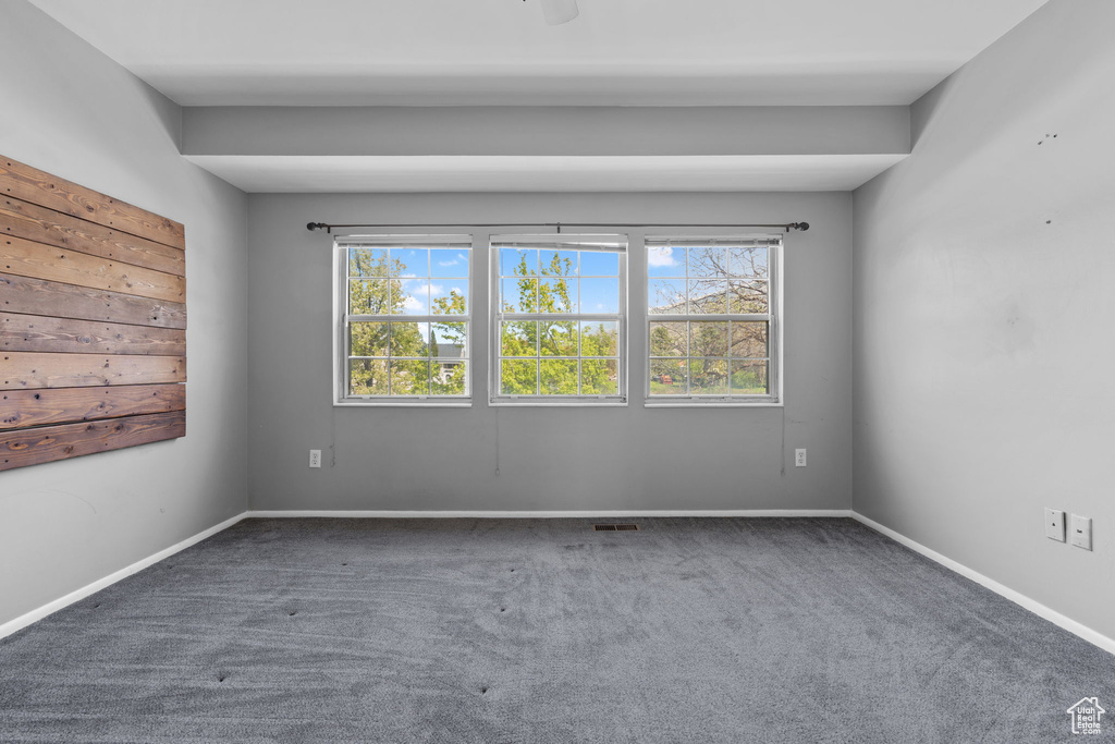 Carpeted empty room featuring baseboards