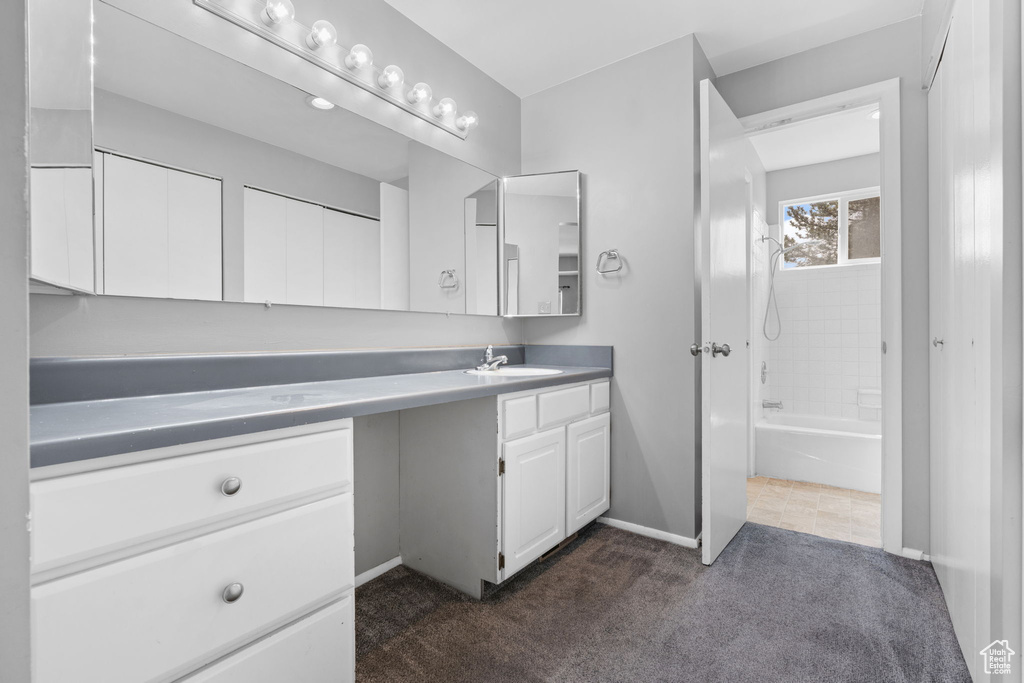 Full bath with vanity, a tub, a shower, carpet, and baseboards