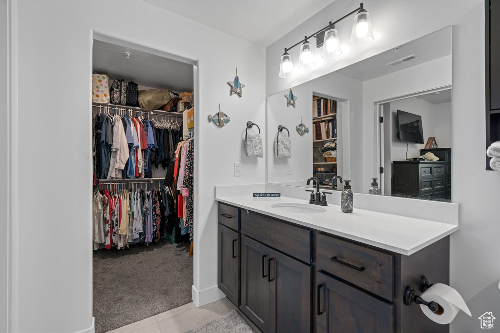 Bathroom featuring a spacious closet, visible vents, tile patterned floors, and vanity