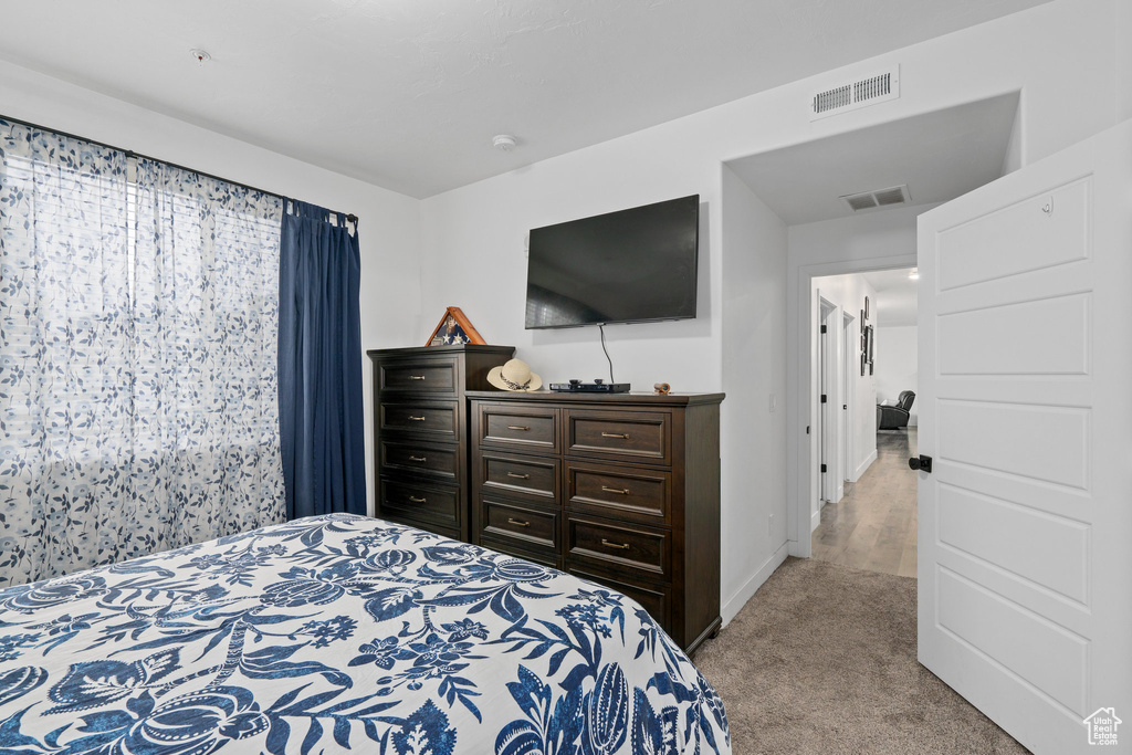 Bedroom featuring visible vents, baseboards, and light carpet