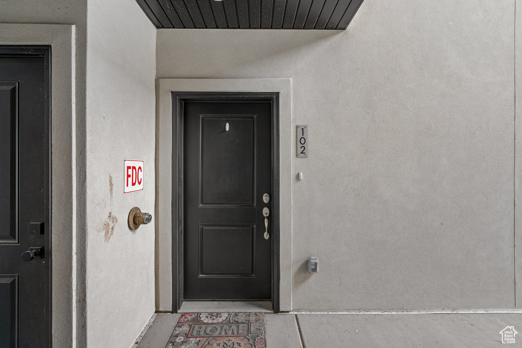 Property entrance featuring visible vents and stucco siding