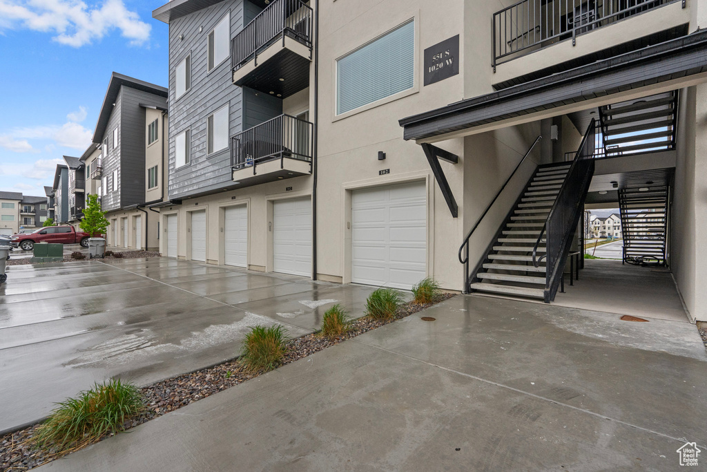 Exterior space featuring an attached garage, driveway, and stairs