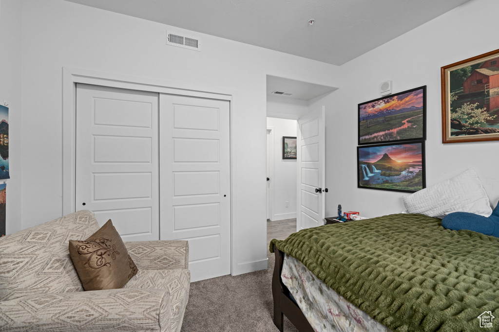 Bedroom with baseboards, visible vents, a closet, and carpet flooring