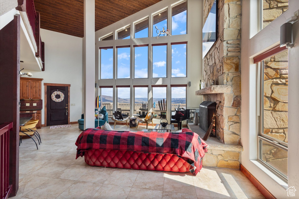 Living room with light tile patterned flooring, a mountain view, wood ceiling, and high vaulted ceiling