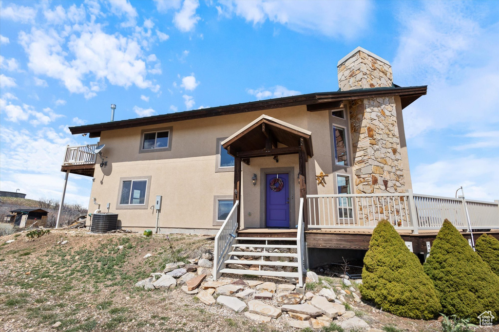 View of front facade featuring a chimney and stucco siding