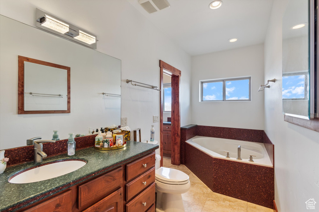 Full bathroom featuring a garden tub, vanity, toilet, visible vents, and recessed lighting