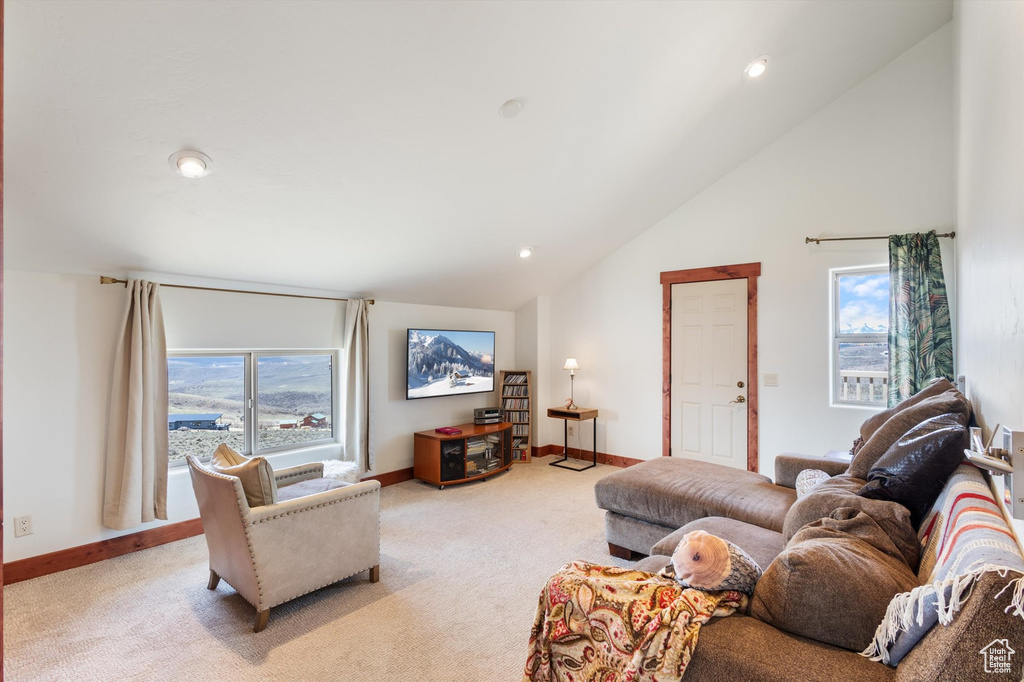 Living area with recessed lighting, baseboards, vaulted ceiling, and light carpet
